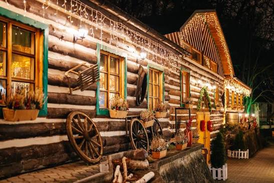 Folklore Garden log-cabin restaurant strung with lights at night